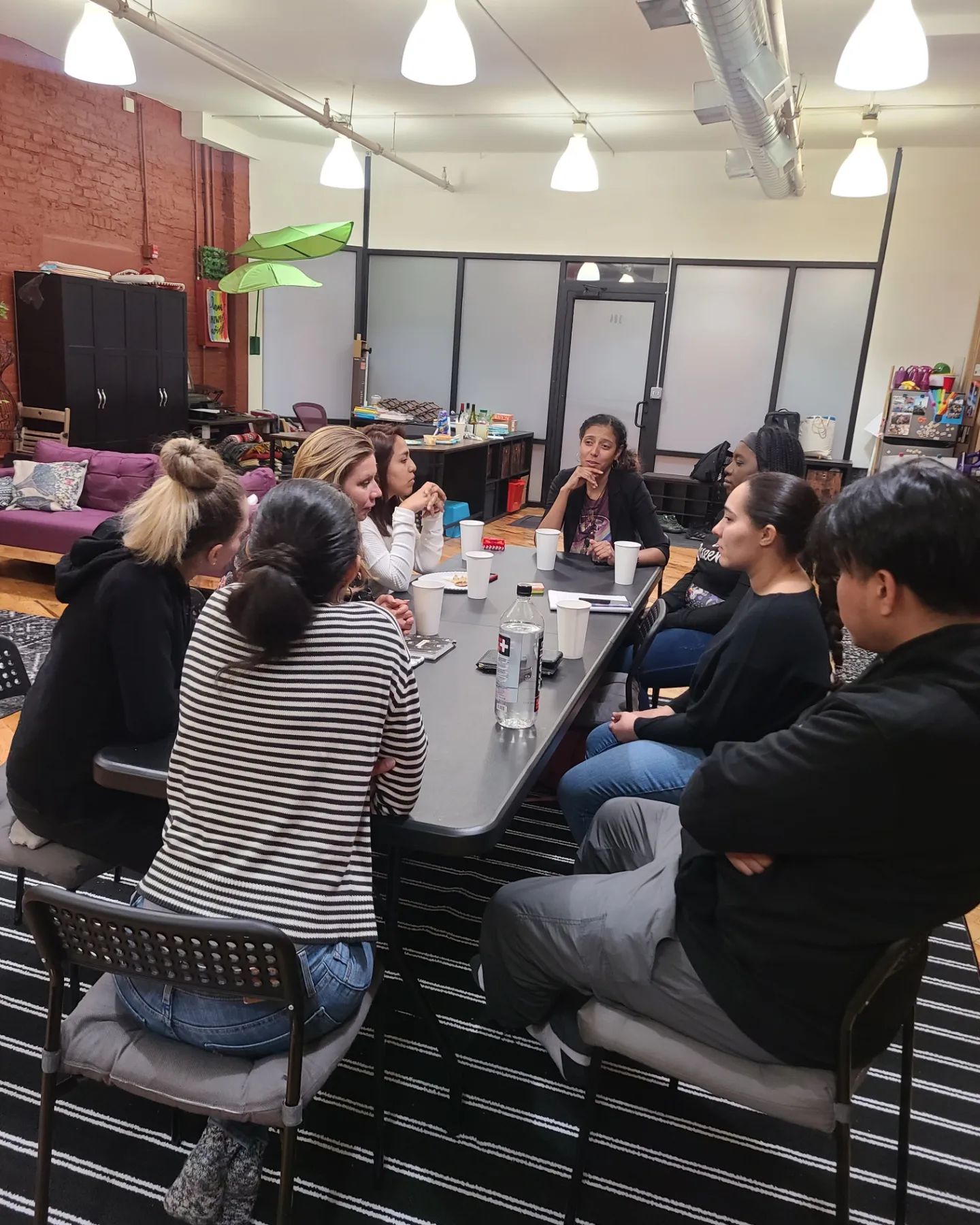 Adults gathered around a table in the common room at Elements Workspace.